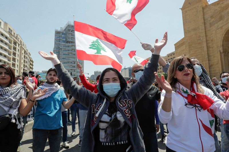 Lebanese anti-government protesters, some wearing protective masks amid the COVID-19 pandemic, gesture during a demonstration against the growing economic hardship in downtown Beirut on May 1, 2020, marking International Workers' Day (Labour Day). (Photo by ANWAR AMRO / AFP) (Photo by ANWAR AMRO/AFP via Getty Images)