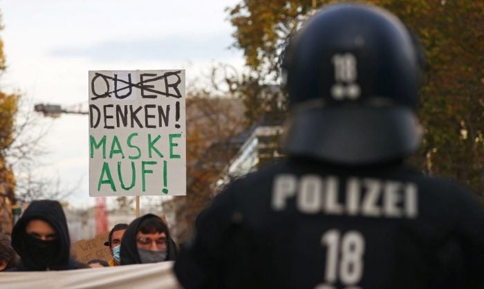 Counter-demonstrators hold up a sign reading "Think! Put a mask on!" as they face off people protesting against the government's restrictions following the coronavirus disease (COVID-19) outbreak, in Frankfurt, Germany, November 14, 2020. REUTERS/Kai Pfaffenbach - RC223K9C5N26