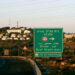 This picture taken from the Rd 60 highway shows the Israeli settlement of Efrata on the southern outskirts of Bethlehem, behind a road sign towards the right locating the settlement block of Gush Etzion, in the occupied West Bank, on June 27, 2020. (Photo by HAZEM BADER / AFP) (Photo by HAZEM BADER/AFP via Getty Images)