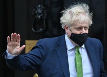 Britain's Prime Minister Boris Johnson, wearing a face covering to help mitigate the spread of coronavirus, waves as he leaves from 10 Downing Street in central London on January 19, 2022, to take part in the weekly session of Prime Minister Questions (PMQs) at the House of Commons. - British Prime Minister Boris Johnson on Wednesday faced signs of an organised revolt in his Conservative party over revelations of lockdown-breaching parties, as he geared up for a grilling in parliament. (Photo by JUSTIN TALLIS / AFP) (Photo by JUSTIN TALLIS/AFP via Getty Images)