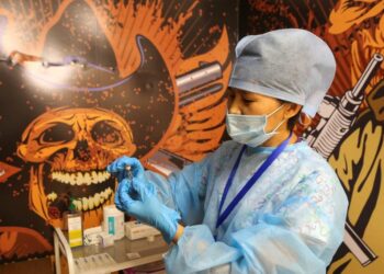 A medical worker holds a vial with the Chinese-developed CoronaVac vaccine against the coronavirus disease (COVID-19) at a temporary vaccination unit set up at a former TikTok studio in the MEGA Park mall in Almaty, Kazakhstan June 23, 2021. REUTERS/Pavel Mikheyev - RC2F6O9N2DQJ