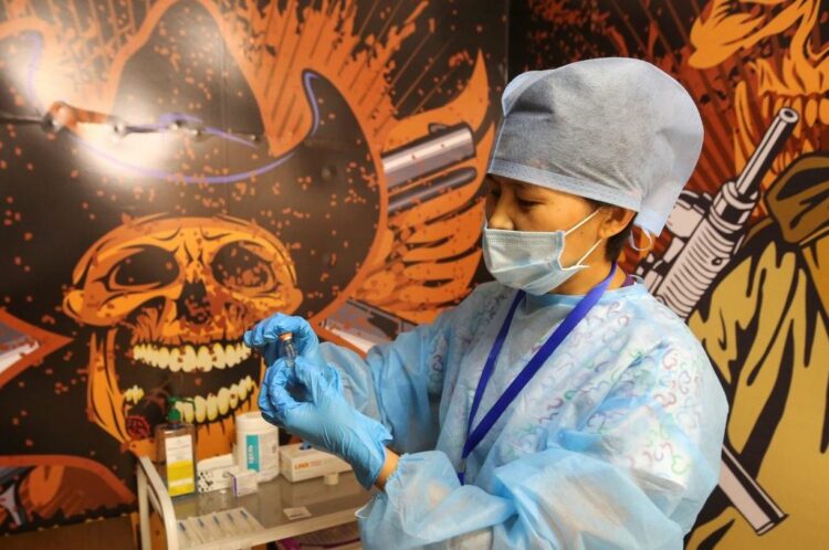 A medical worker holds a vial with the Chinese-developed CoronaVac vaccine against the coronavirus disease (COVID-19) at a temporary vaccination unit set up at a former TikTok studio in the MEGA Park mall in Almaty, Kazakhstan June 23, 2021. REUTERS/Pavel Mikheyev - RC2F6O9N2DQJ