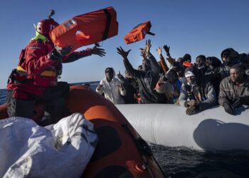 Migrants from Africa sailing adrift on an overcrowded rubber boat, receive life jackets from aid workers of the Spanish NGO Aita Mary in the Mediterranean Sea, about 103 miles (165 kms.) from Libya coast on Friday Jan. 28, 2022. (AP Photo/Pau de la Calle)