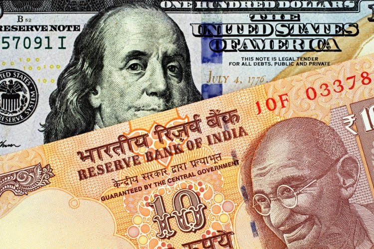 An orange Indian ten rupee bank note, close up, with an American one hundred dollar bill