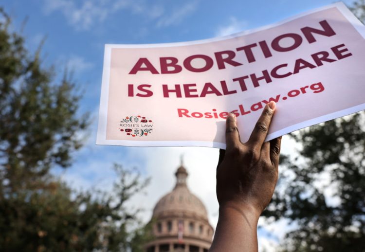A supporter of reproductive rights holds a sign outside the Texas State Capitol building during the nationwide Women's March, held after Texas rolled out a near-total ban on abortion procedures and access to abortion-inducing medications, in Austin, Texas, U.S. October 2, 2021. Picture taken October 2, 2021. REUTERS/Evelyn Hockstein