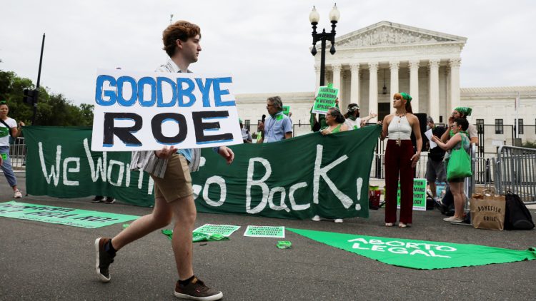 An anti-abortion protester walks past abortion rights supporters outside the United States Supreme Court in Washington, U.S., June 21, 2022. REUTERS/Evelyn Hockstein