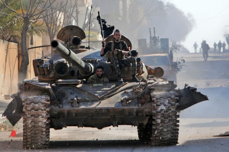 Turkey-backed Syrian fighters ride a tank in the town of Saraqib in the eastern part of the Idlib province in northwestern Syria, on February 27, 2020. - Syrian rebels reentered the key northwestern crossroads town of Saraqib lost to government forces earlier this month but fierce fighting raged on in its outskirts today, an AFP correspondent reported. (Photo by Bakr ALKASEM / AFP) (Photo by BAKR ALKASEM/AFP via Getty Images)
