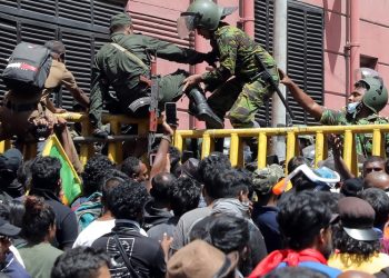 COLOMBO, SRI LANKA â JULY 9: Sri Lankan soldiers and Police Special Task Force personnel jump across the steel barriers as protestors attempt to push them down at the approach road to Presidentâs House, the official residence of the President in Colombo, Sri Lanka, 09 July 2022. Months into the countryâs worst-ever economic crisis, thousands of protesters in Sri Lanka on Saturday stormed the presidentâs official residence and demanded his immediate resignation, local media reported. Holding Sri Lankan flags and helmets, some protesters broke through police barricades and entered President Gotabaya Rajapaksaâs residence in the capital Colombo, leading law enforcement to fire in the air to disperse them, according to video from local TV news channel NewsFirst. Local media claimed that Rajapaksa left the residence and was taken to a safe place. TV footage shows some of these protestors bursting through the gates of the presidential secretariat on the seafront, which has been the site of a sit-in protest for months. Prime Minister Ranil Wickremesinghe called an emergency meeting of political party leaders amid growing anger over the governmentâs handling of the economic crisis. (Photo by M.A. Pushpa Kumara/Anadolu Agency via Getty Images)