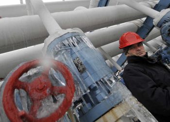A local visitor walks stands next to frozen gas equipment at a natural gas control center of German E-On Natural Gas Storage Closed Company Limited in Hajduszoboszlo, more than 200 kms east of Budapest, on January 7, 2009. Supplies of Russian gas to Bulgaria, Greece, Hungary, Macedonia, Serbia, Slovakia and Turkey were halted for a third day on January 8 amid a Russian-Ukrainian price dispute.  Russian and Ukrainian energy chiefs held talks in Moscow overnight on January 8 for the first time since the start of a gas crisis that has seen gas supplies cut off across Europe in a bitterly cold winter.  AFP PHOTO /ATTILA KISBENEDEK (Photo by Attila KISBENEDEK / AFP)