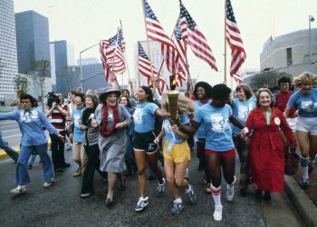 ADVANCE FOR USE MONDAY, JUNE 20, 2016 AND THEREAFTER -FILE - In this November 1977 file photo, leaders of the women's movement pass a torch that was carried by foot from New York to Houston, Texas for the National Women's Convention. Among the marchers, from left foreground are tennis star Billie Jean King, in blue shirt and tan pants; former U.S. Congresswoman Bella Abzug, wearing a hat; and feminist writer Betty Friedan, in a red coat. (AP Photo/Greg Smith)