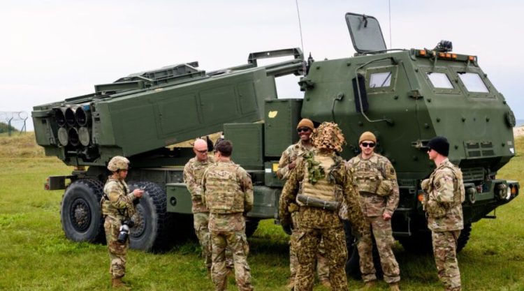 Military personnel stands in front of a High Mobility Artillery Rocket Systems (HIMARS) during the military exercise Namejs 2022 on September 26, 2022 in Skede, Latvia. (Photo by Gints Ivuskans / AFP) (Photo by GINTS IVUSKANS/AFP via Getty Images)