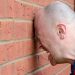 a man banging his head agaist the wall in frustration
