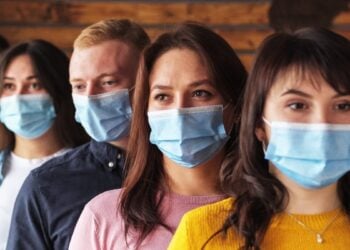Crowd of young people wearing masks on their faces during the coronavirus pandemic - New normal masked millennials - New concept of normal life