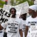 WASHINGTON, DC - AUGUST 03: Black supporters of former U.S. President Donald Trump carry signs in front of the E. Barrett Prettyman United States Courthouse on August 03, 2023 in Washington, DC. Former U.S. President Donald Trump is scheduled to be arraigned this afternoon after being indicted on four felony counts for his alleged efforts to overturn the 2020 election. (Photo by Kent Nishimura/Getty Images)