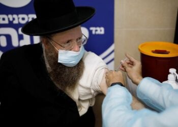 An ultra-Orthodox Jewish man receives a vaccination against the coronavirus disease (COVID-19) as Israel continues its national vaccination drive, during a third national COVID lockdown, in Ashdod, Israel January 4, 2021. Picture taken January 4, 2021. REUTERS/Amir Cohen